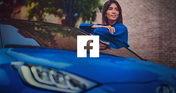 Fiatal, mosolygó nő egy kék Toyota motorháztetejére támaszkodik, középen a Facebook logóval.