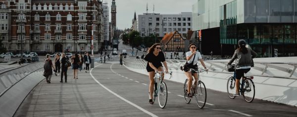 Women biking on bridge in Copenhagen