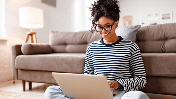 woman smiling while looking at her laptop