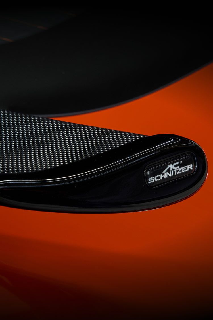 Nahaufnahme eines schwarzen Spoilers eines rotens Sportwagens mit dem Logo AC Schnitzer an der Seite