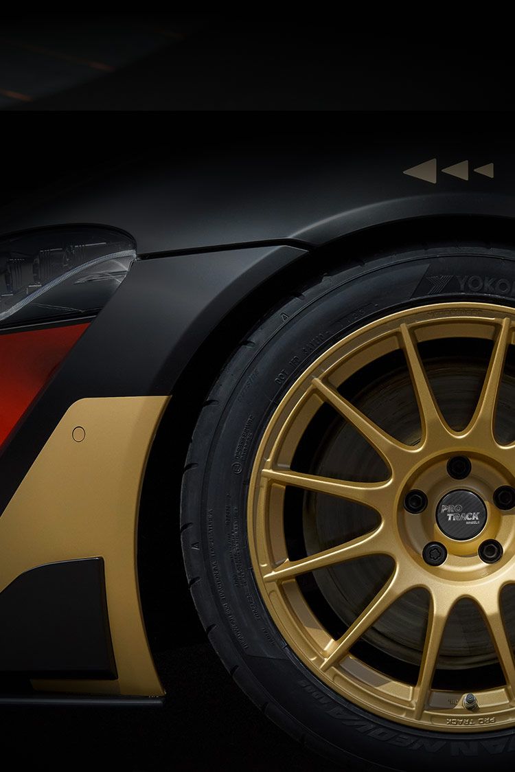 Seitenansicht eines Profils von goldfarbenen Felgen mit der Schrift Protrack in der Mitte und schwarz rot goldenen Akzenten auf der Karrosserie