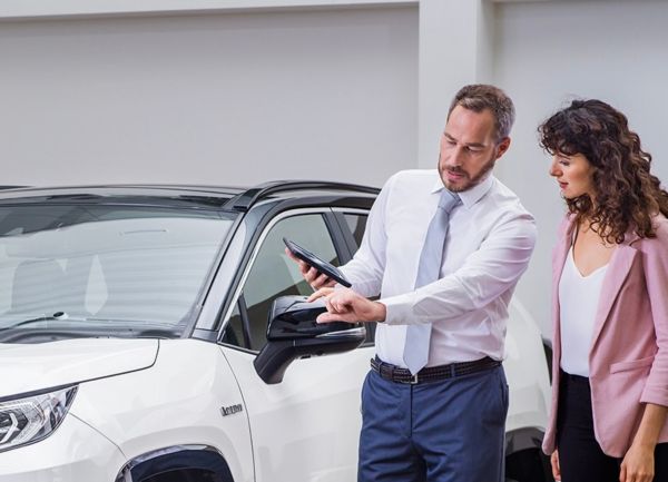 two people next to a Toyota car