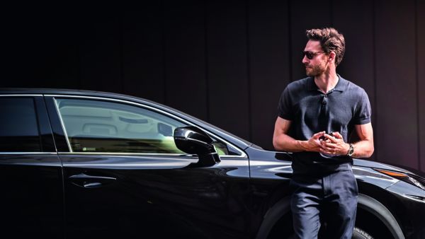 A man leaning on to his Lexus