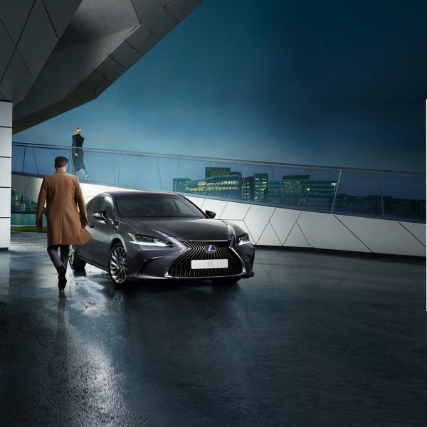мъж върви към Lexus автомобил