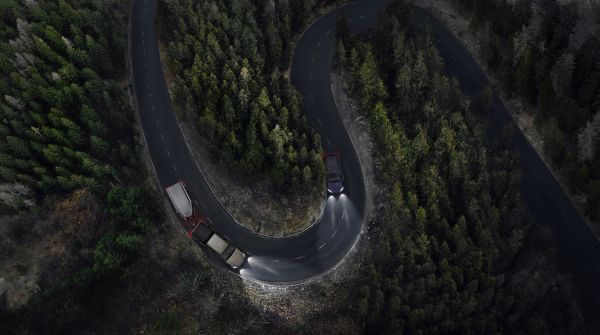Toyota Hilux met paardertrailier rijdt in een haarspeldbocht in het donker.