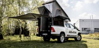 Bílé terénní auto s rozkládacím střešním stanem a markýzou.