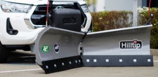 Sněžná radlice Hilltip před bílým autem.