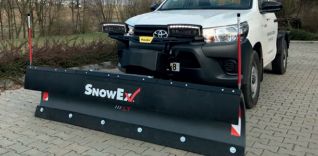 Bílé terénní vozidlo s čelním sněhovým pluhem SnowEx.