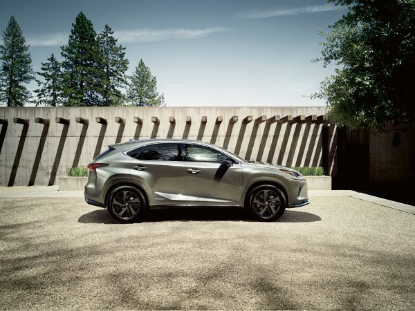 A man walking towards a parked Lexus 