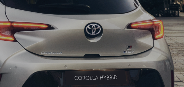 Zbliżenie tylenj klapy bagażnika Corolli Hybrid z logotypami.