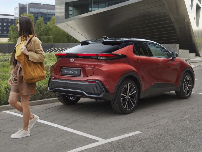 Žluté Toyota Yaris Cross Hybrid jedoucí po městské ulici.