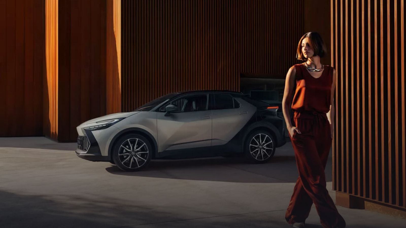 Gri Toyota C-HR Hybrid yanında duran bir kadın