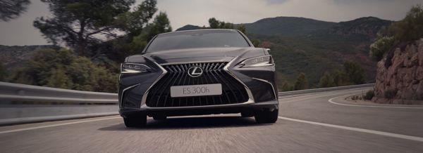 Une Lexus ES roulant sur une route de campagne, mettant en valeur son design moderne et ses caractéristiques distinctives.