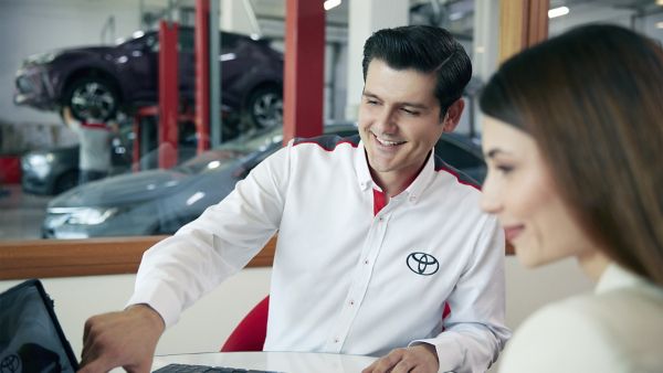 müşteriye tablet ekranını gösteren bir Toyota çalışanı