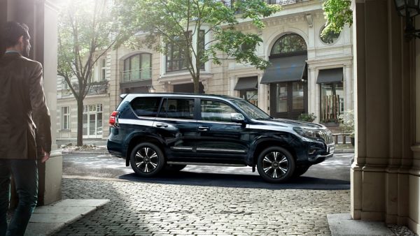 Toyota Land Cruiser parked in a street with a man walking towards it