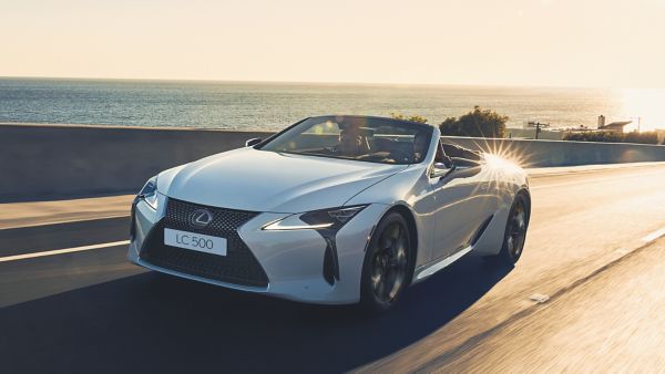 Ein Lexus LC Cabrio fährt mit offenem Verdeck auf einer Küstenstraße