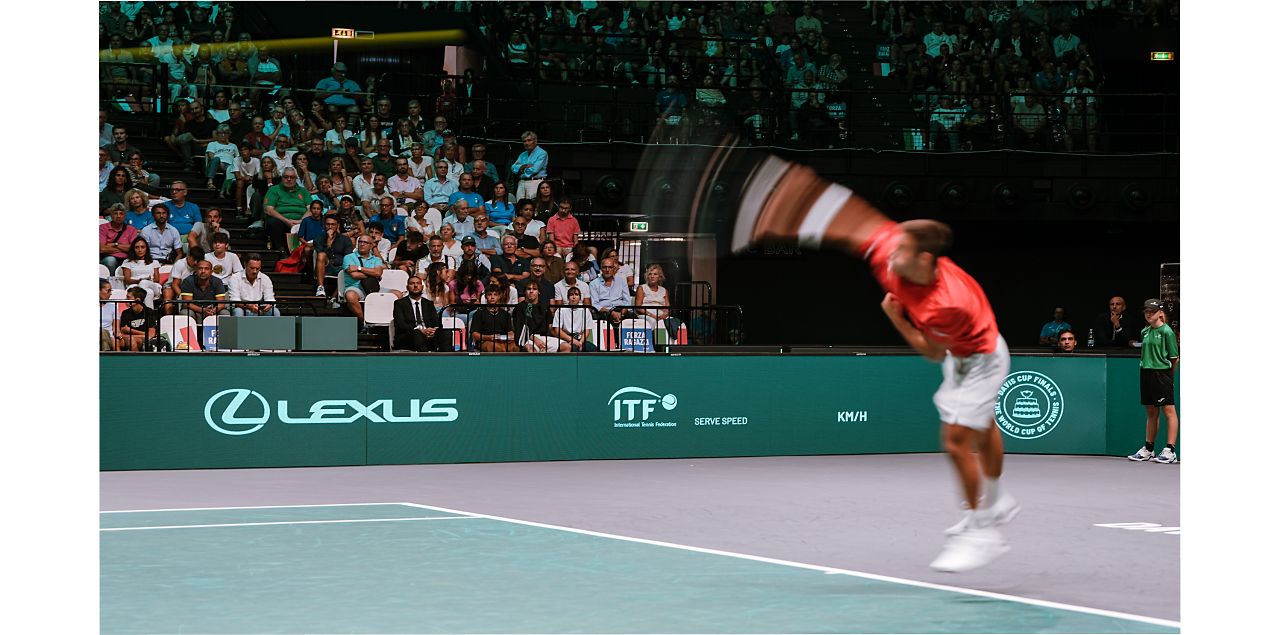 A tennis player serving on a Lexus X ATP court