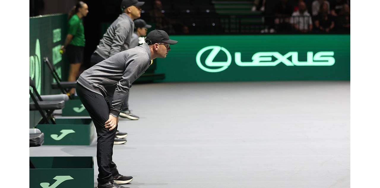 Line judges stood at the side of a tennis court