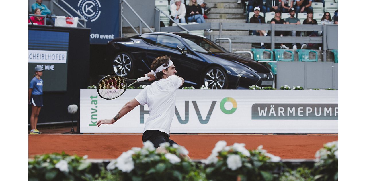 Roger Federer on a tennis court with a Lexus in the background