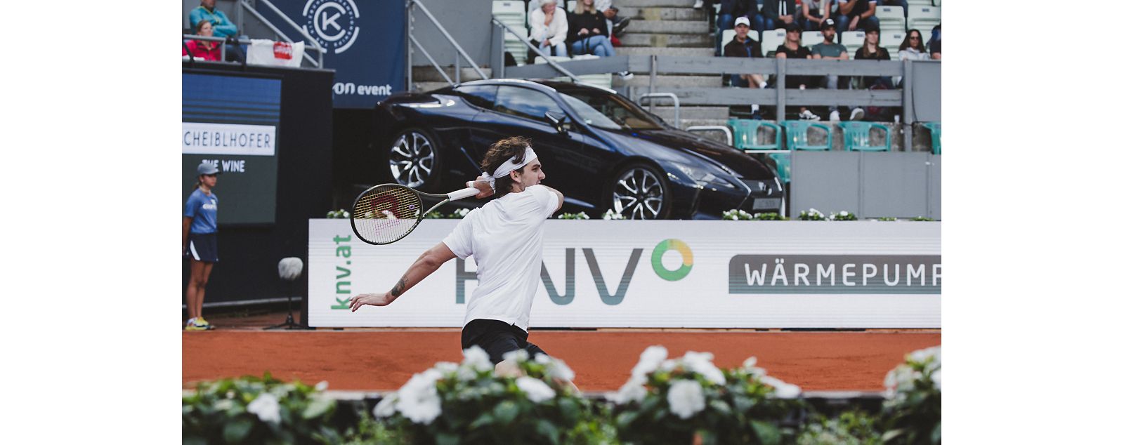 Roger Federer on a tennis court with a Lexus in the background