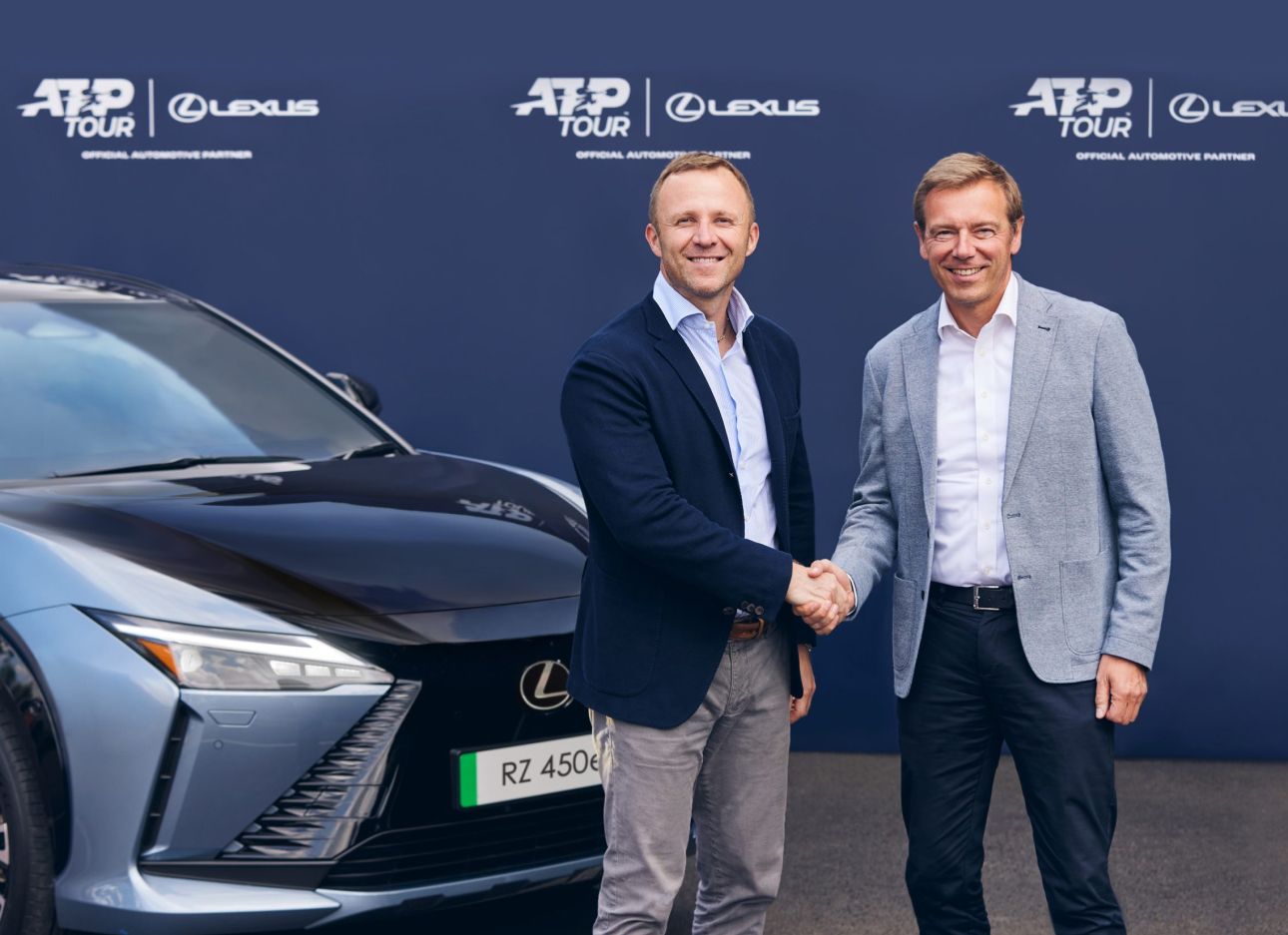 Twee mannen staan voor een Lexus RZ en schudden elkaar de hand...