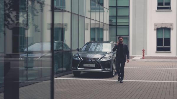 man leaning on a Lexus car