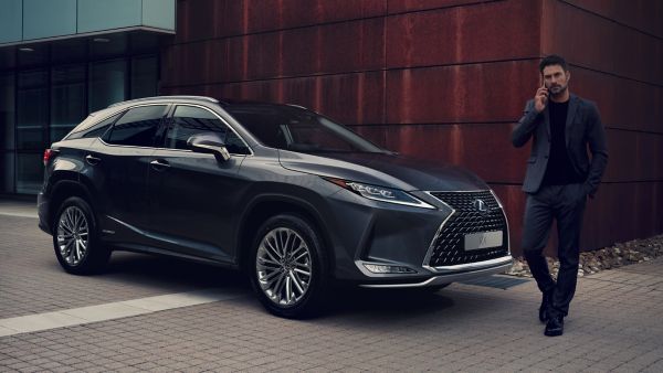 man in suit standing next to a Lexus RX