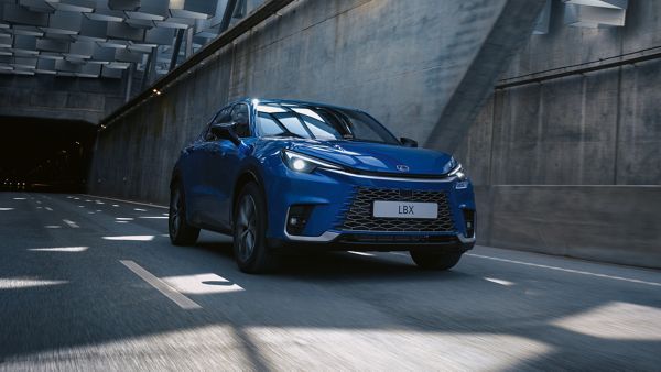 A blue Lexus LBX driving under a tunnel