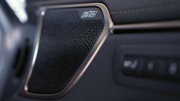 Nahaufnahme eines Mark Levinson Premium-Lautsprechergitters in einem Autoinnenraum, das mit seinem komplizierten Design und den polierten Zierleisten die Klangqualität verbessert.