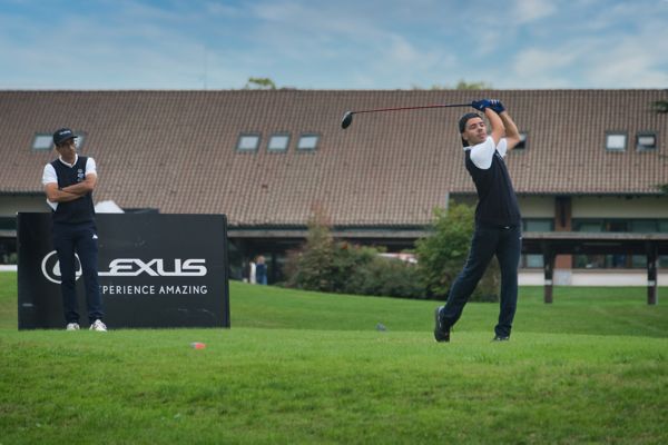 A golfer teeing off, while another golfer looks on