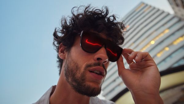 A man with a Lexus reflecting in his sunglasses