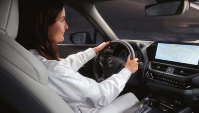 Fahrerin im Innenraum eines Lexus mit Blick auf Navigationsdisplay.