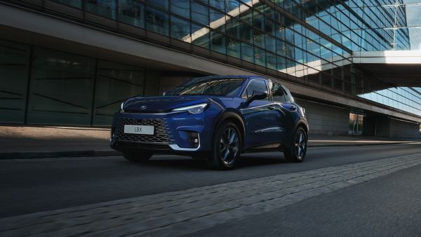 A blue Lexus LBX driving on a city street