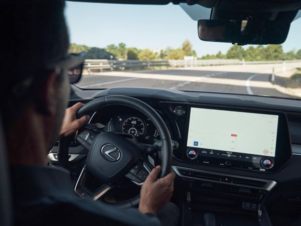 Perspektive eines Fahrers in einem Lexus mit Sicht auf das Navigationssystem und die Straße