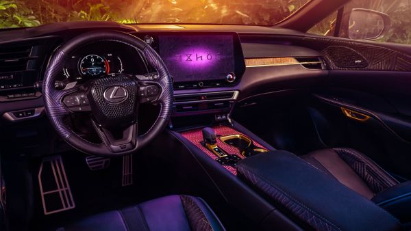 Elegantes Lexus-Autointerieur mit einem modernen Armaturenbrett, einem großen Bildschirm und einem detaillierten Lenkrad, eingebettet in ein warmes Umgebungslicht.