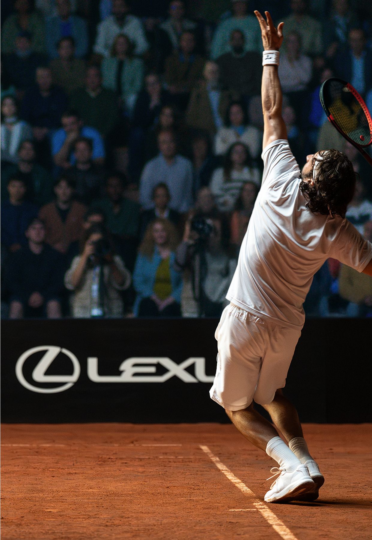 Ein Tennisspieler beim Aufschlag, im Hintergrund ist das Lexus Logo auf der Bande zu sehen