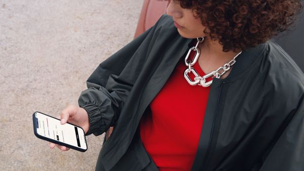 Osoba korzystająca z telefonu komórkowego w celu uzyskania dostępu do aplikacji Lexus Link
