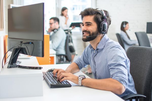 Man at desktop computer with headset