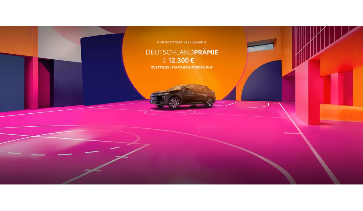 Ein Fahrzeug von Toyota steht auf einem pinken Basketballfeld vor einer orangenen Kugel. Die Wände sind in bunten Formen bemalt.