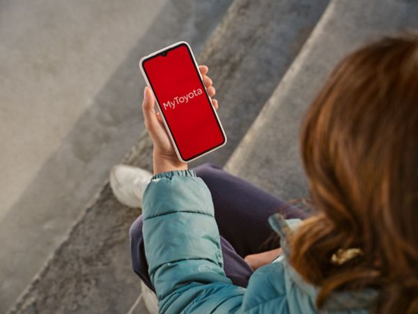 Femme avec son smartphone connectée à l'application MyToyota