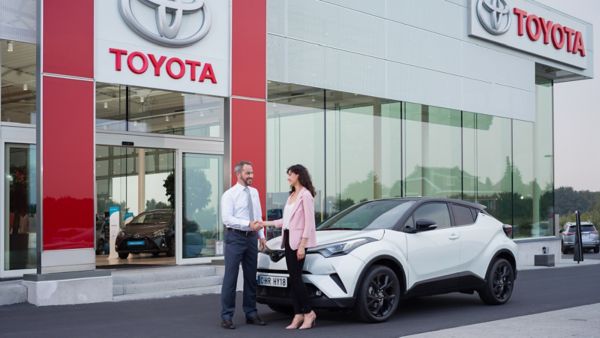 Klient odbiera nowe auto w salonie Toyota