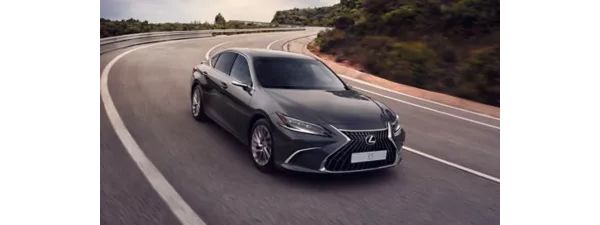 Ein dunkelgrauer Lexus ES fährt eine kurvige Bergstraße entlang