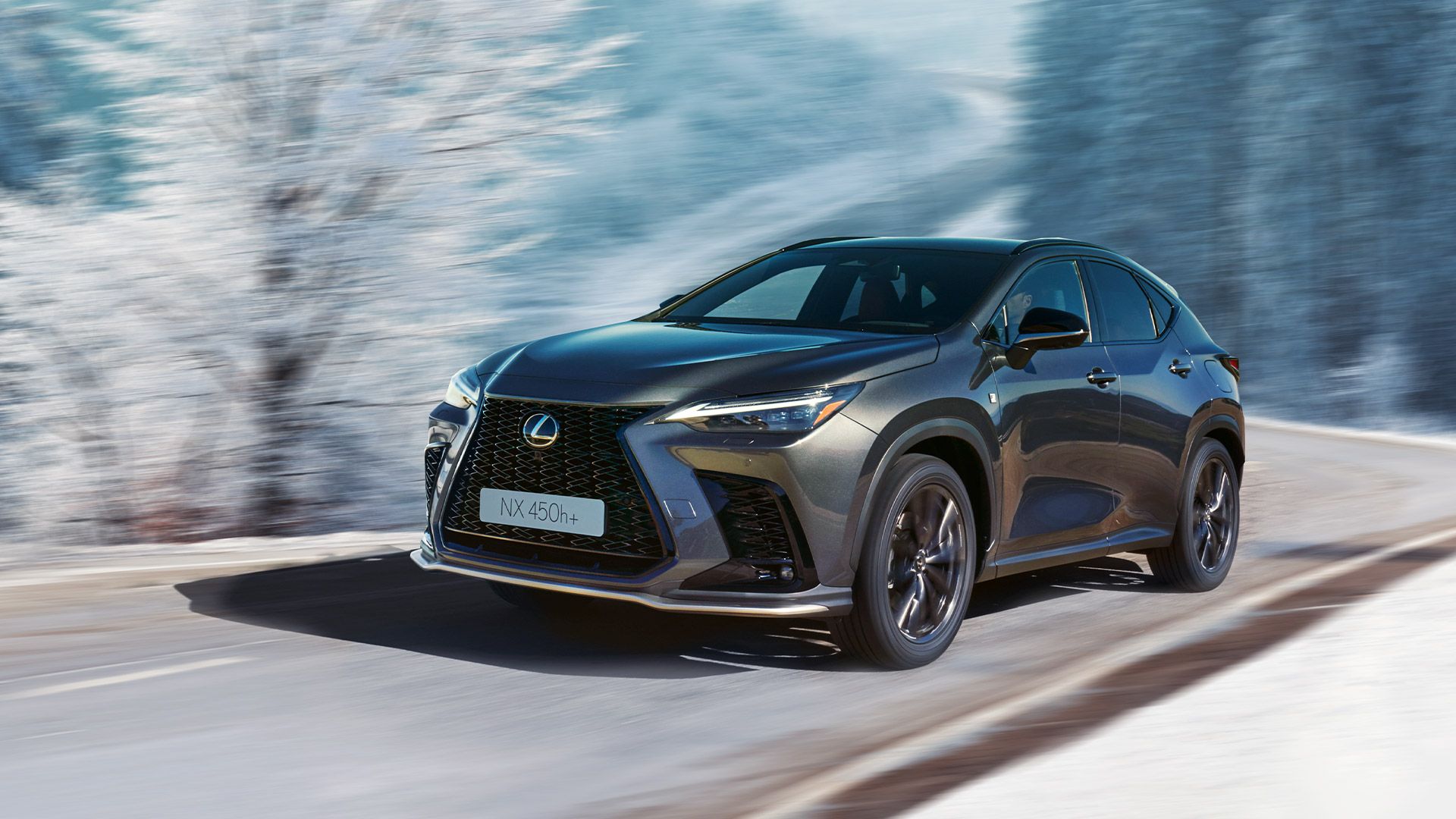 Ein eleganter silberner Lexus SUV fährt auf einer verschneiten Straße