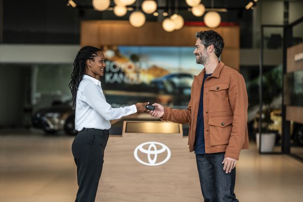 two people exchanging keys inside a Toyota centre