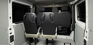 Interiér dodávky s třemi sedadly.