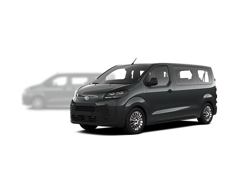 Grauer Toyota Proace Verso steht diagonal zur Kamera, im Hintergrund ist unscharf ein grauer Proace Verso zu erkennen