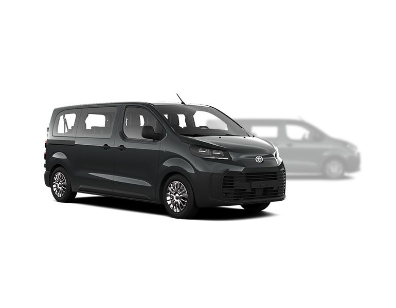 Grauer Toyota Proace Verso steht diagonal zur Kamera, im Hintergrund ist unscharf ein grauer Proace Verso zu erkennen
