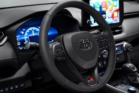Řidičův prostor Toyoty RAV4 s multimediálním systémem a digitálním přístrojovým panelem.