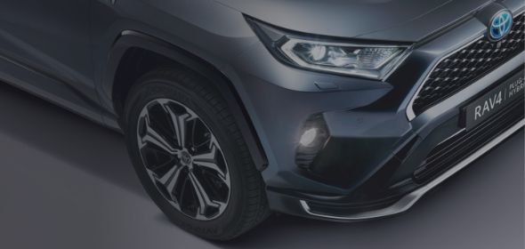 Zbliżenie na przedni grill i koło Toyoty RAV4 Plug-in Hybrid.