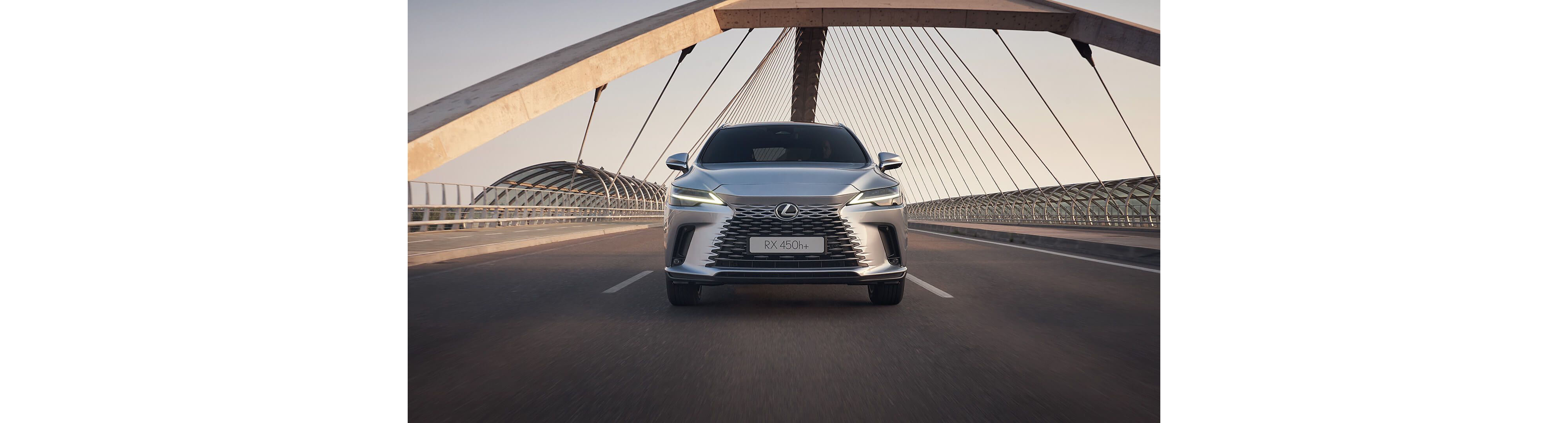Front view of the Lexus RX 450h+ driving over a bridge